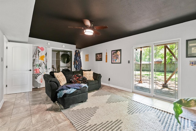 102 Oxford Cv, Jacksonville, AR 72076 - living room featuring ceiling fan, baseboards, stacked washer / dryer, and light tile patterned floors