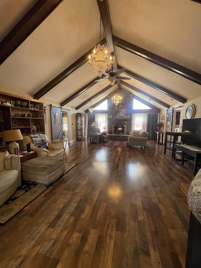 unfurnished living room featuring a stone fireplace, lofted ceiling with beams, ceiling fan with notable chandelier, and wood finished floors