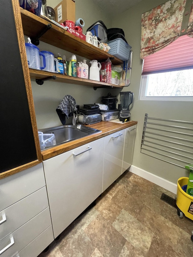 interior space with baseboards and a sink