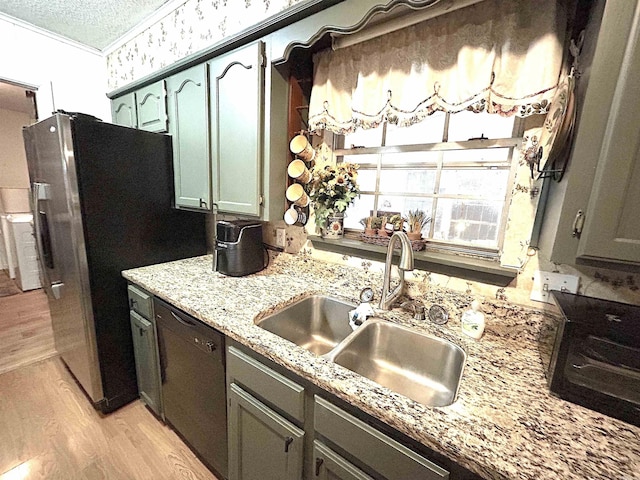 kitchen with stainless steel fridge with ice dispenser, a sink, black dishwasher, light wood-style floors, and a textured ceiling