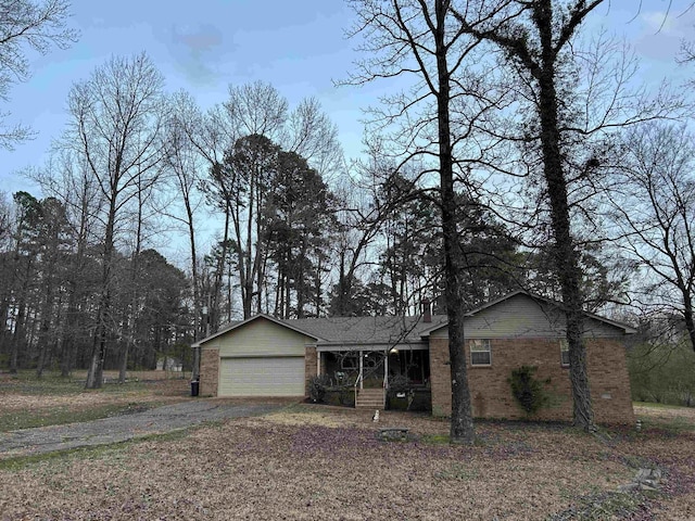 single story home featuring brick siding, an attached garage, and driveway