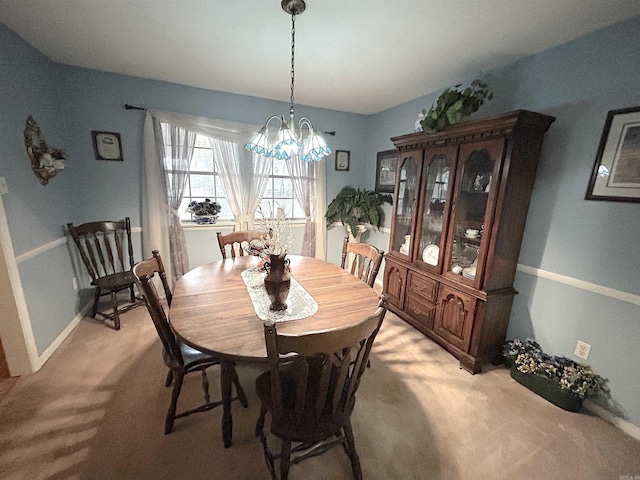 dining area with a notable chandelier, baseboards, and light colored carpet