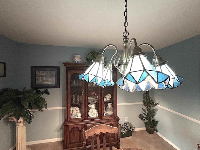 details featuring carpet flooring, baseboards, and an inviting chandelier