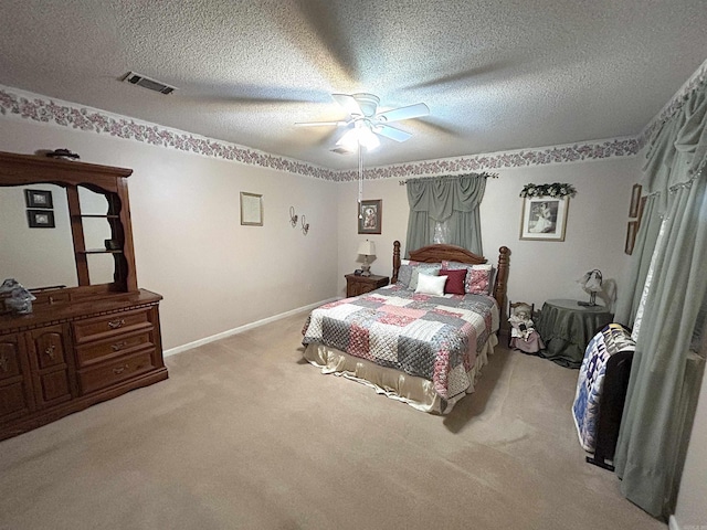 carpeted bedroom with visible vents, baseboards, a textured ceiling, and ceiling fan