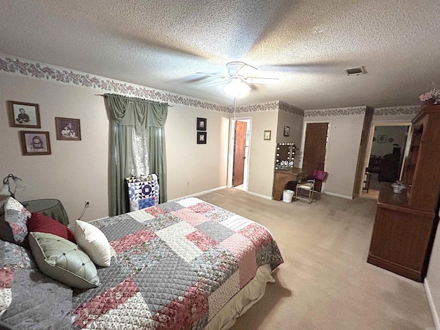 carpeted bedroom with visible vents, baseboards, a textured ceiling, and a ceiling fan