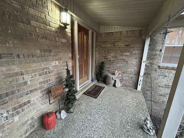 doorway to property featuring brick siding