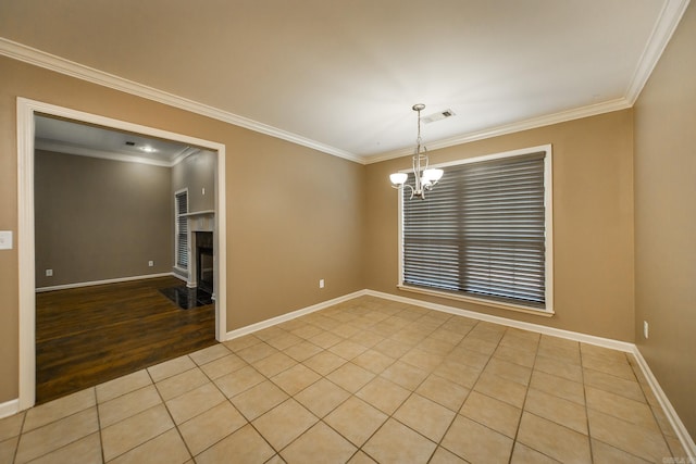 unfurnished room with baseboards, visible vents, a chandelier, and ornamental molding