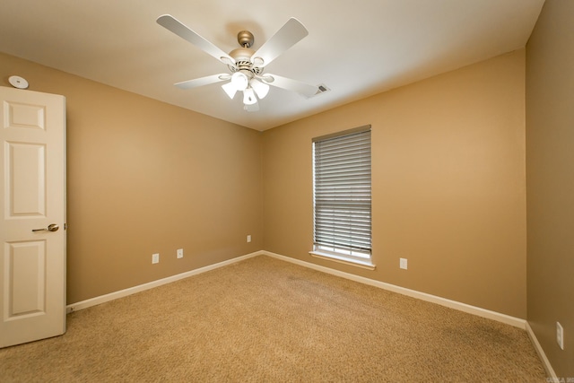 empty room featuring light colored carpet, baseboards, and ceiling fan