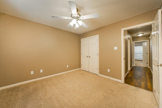 unfurnished bedroom featuring a closet, baseboards, carpet, and a ceiling fan