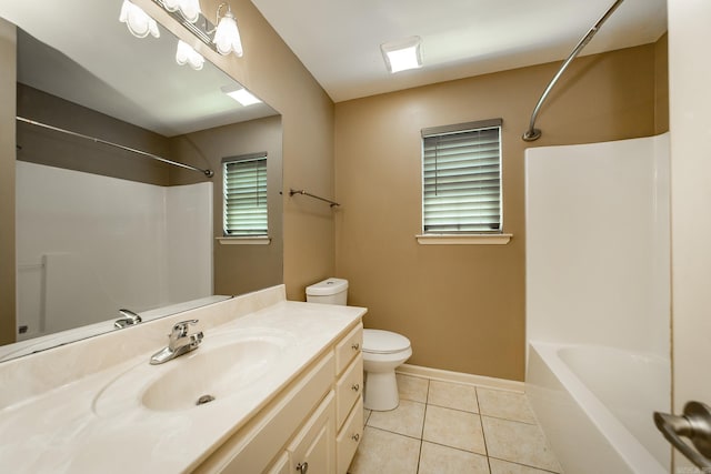 bathroom with vanity, baseboards, tile patterned floors, toilet, and shower / bathtub combination