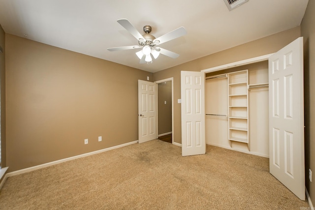 unfurnished bedroom featuring visible vents, a closet, baseboards, light colored carpet, and ceiling fan