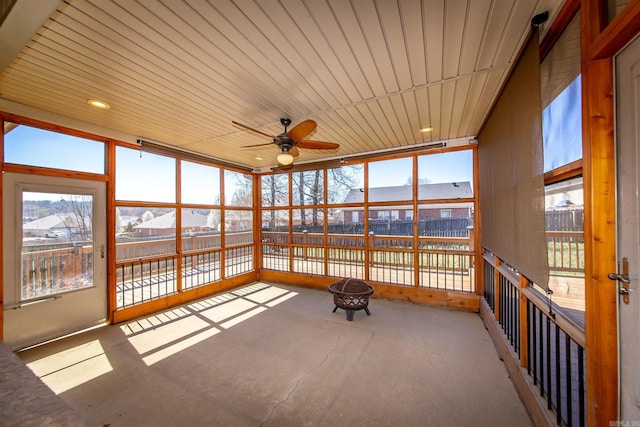 unfurnished sunroom with ceiling fan