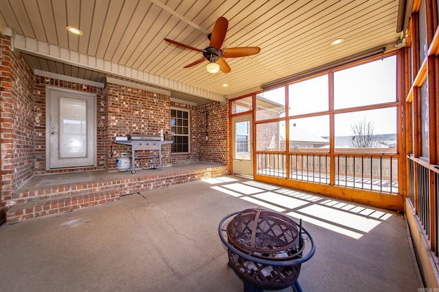 unfurnished sunroom with ceiling fan and wooden ceiling