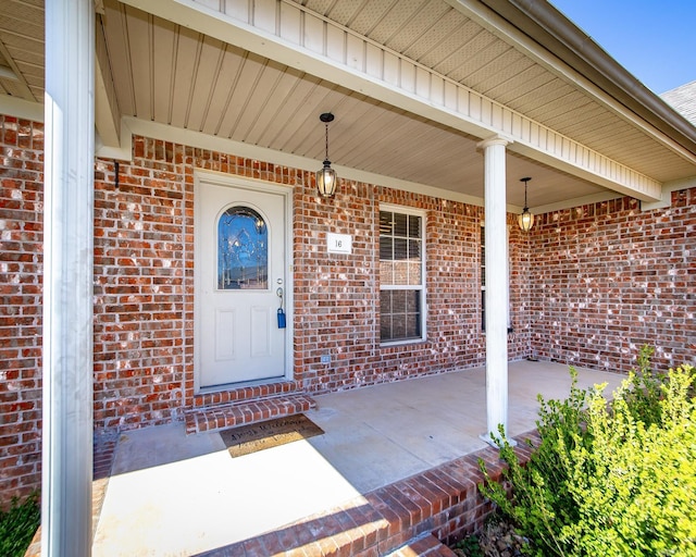 property entrance with brick siding and a porch