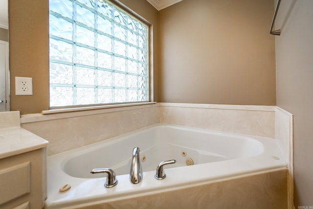 full bath featuring vanity, a tub with jets, and a wealth of natural light