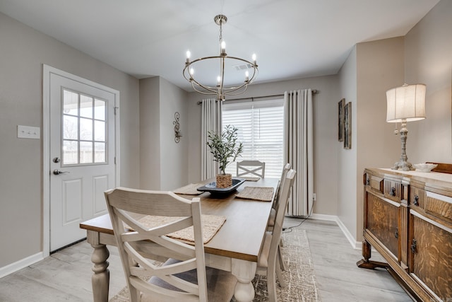 dining space with light wood-style flooring, baseboards, visible vents, and a chandelier