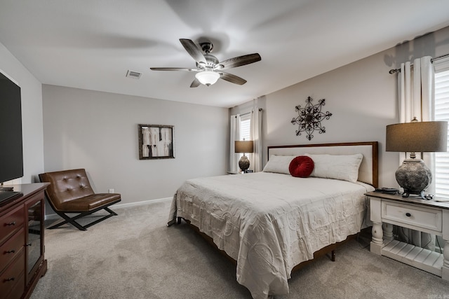 carpeted bedroom with visible vents, baseboards, and a ceiling fan