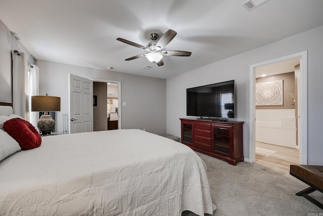 bedroom featuring ensuite bath, carpet, visible vents, and ceiling fan