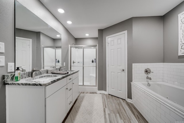 bathroom with a shower stall, double vanity, a whirlpool tub, and a sink