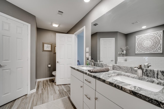 bathroom featuring toilet, visible vents, and a sink