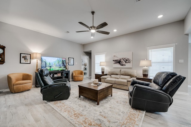 living area featuring visible vents, baseboards, light wood-style floors, and ceiling fan