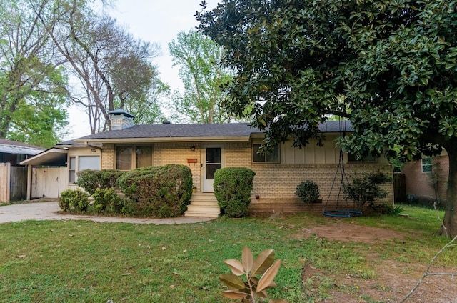 single story home featuring a garage, driveway, brick siding, and a front yard