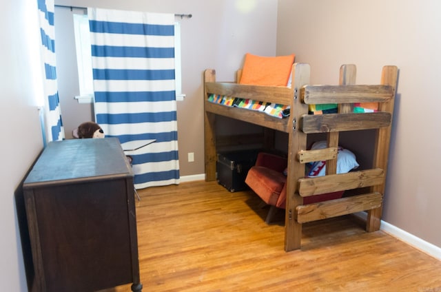 bedroom with baseboards and light wood-type flooring