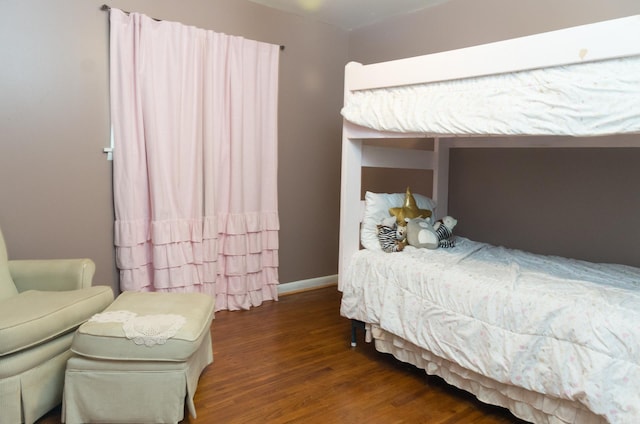 bedroom with baseboards and wood finished floors