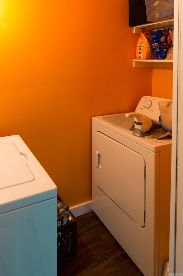 washroom with washer and dryer, baseboards, dark wood finished floors, and laundry area