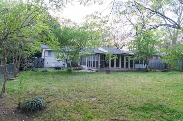 view of yard with a sunroom and fence