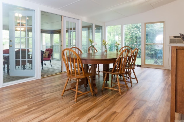 dining area featuring light wood-style flooring and vaulted ceiling