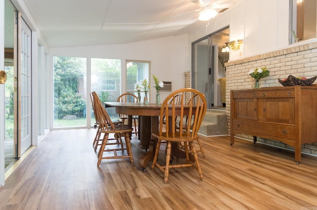 dining area featuring ceiling fan, light wood-style floors, and vaulted ceiling