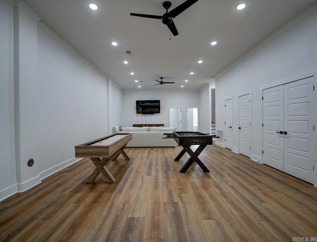 recreation room featuring wood finished floors, ceiling fan, and ornamental molding