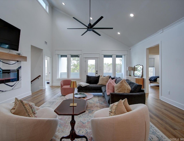 living area featuring a ceiling fan, wood finished floors, and a healthy amount of sunlight