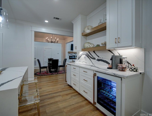 kitchen featuring open shelves, wine cooler, white cabinetry, a notable chandelier, and light wood-type flooring