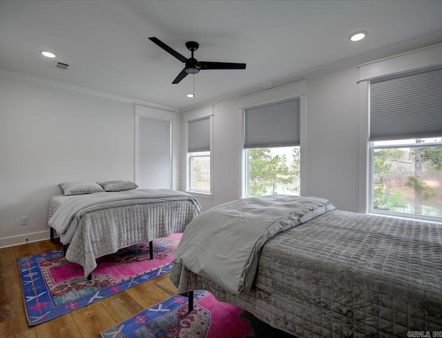 bedroom featuring hardwood / wood-style floors, visible vents, and ornamental molding