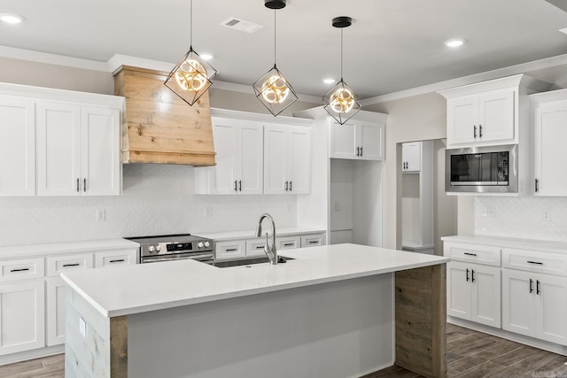 kitchen featuring visible vents, ornamental molding, a sink, wood finished floors, and stainless steel appliances