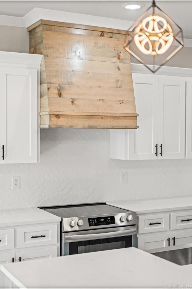 kitchen featuring decorative light fixtures, backsplash, stainless steel electric range, and white cabinets