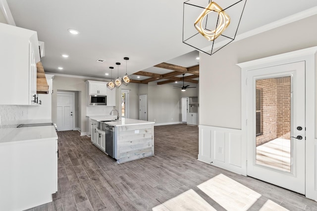 kitchen featuring light wood finished floors, beamed ceiling, appliances with stainless steel finishes, white cabinets, and coffered ceiling