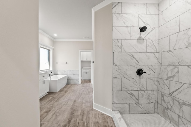 bathroom with a freestanding bath, ornamental molding, wood finished floors, and tiled shower