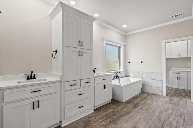 bathroom featuring vanity, crown molding, wood finished floors, and visible vents