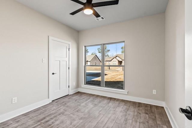 spare room with visible vents, baseboards, ceiling fan, and wood finished floors