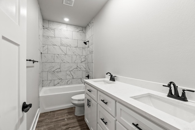 full bathroom with wood finish floors, toilet, visible vents, and a sink