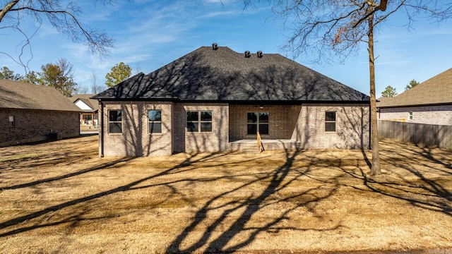 back of property with brick siding and fence