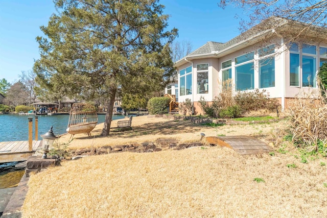 view of yard with a dock and a water view