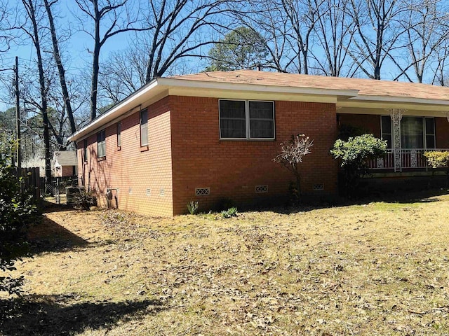 view of home's exterior featuring crawl space, brick siding, and fence