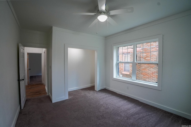 unfurnished bedroom featuring ceiling fan, baseboards, carpet floors, and ornamental molding