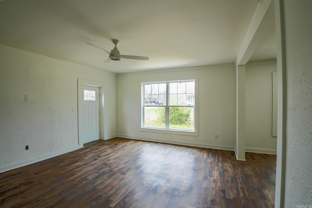 interior space featuring baseboards, a ceiling fan, and dark wood-style flooring