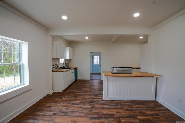 kitchen featuring a sink, a healthy amount of sunlight, dark wood-style floors, and butcher block counters