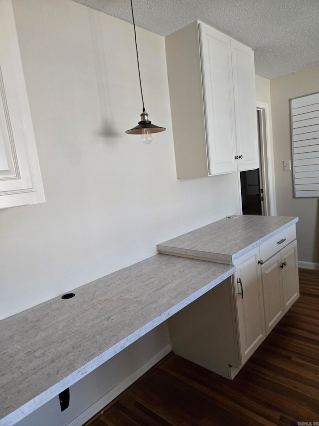 kitchen with a textured ceiling, white cabinetry, dark wood-type flooring, and light countertops